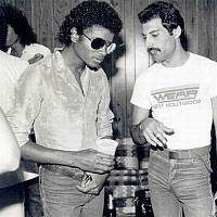 Michael a Freddie, v pozadí skrytý Brian May